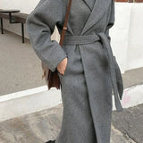 Cappotto lungo da donna con cintura e revers elegante