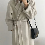 Cappotto lungo da donna con cintura e revers elegante