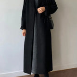 Cappotto lungo da donna con cintura e revers elegante